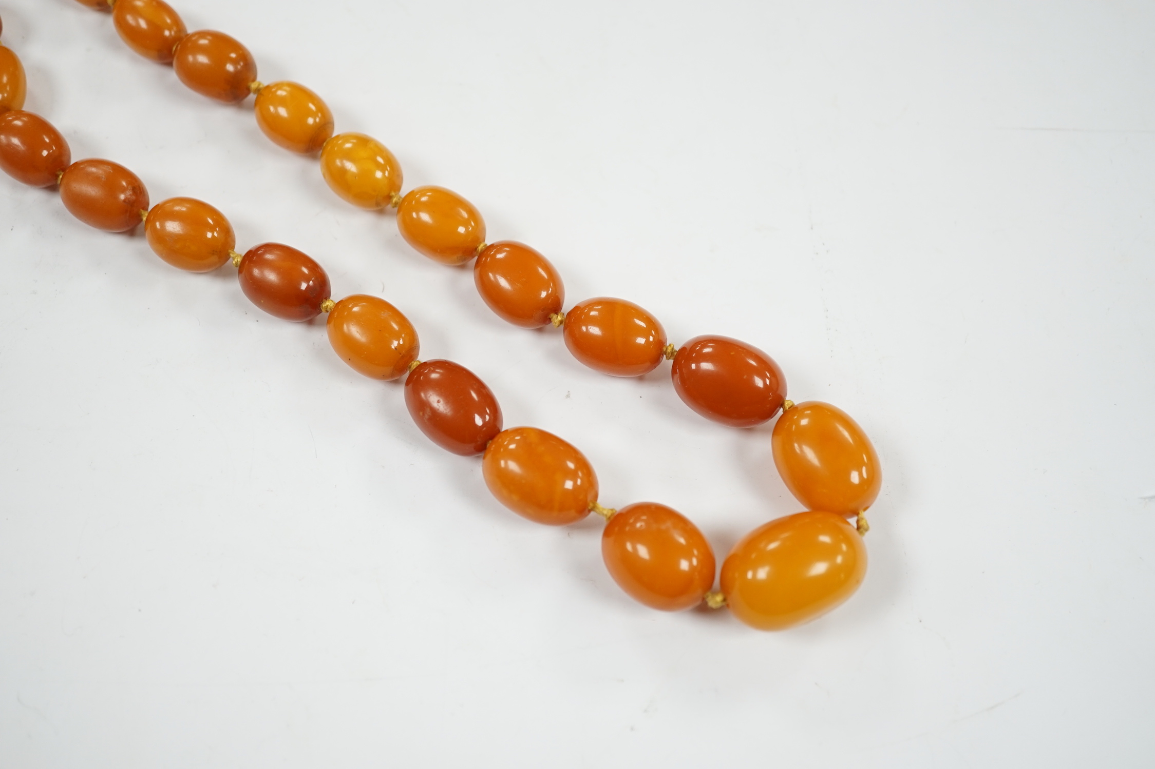 A single strand graduated oval amber bead necklace, 114cm, gross weight 84 grams.